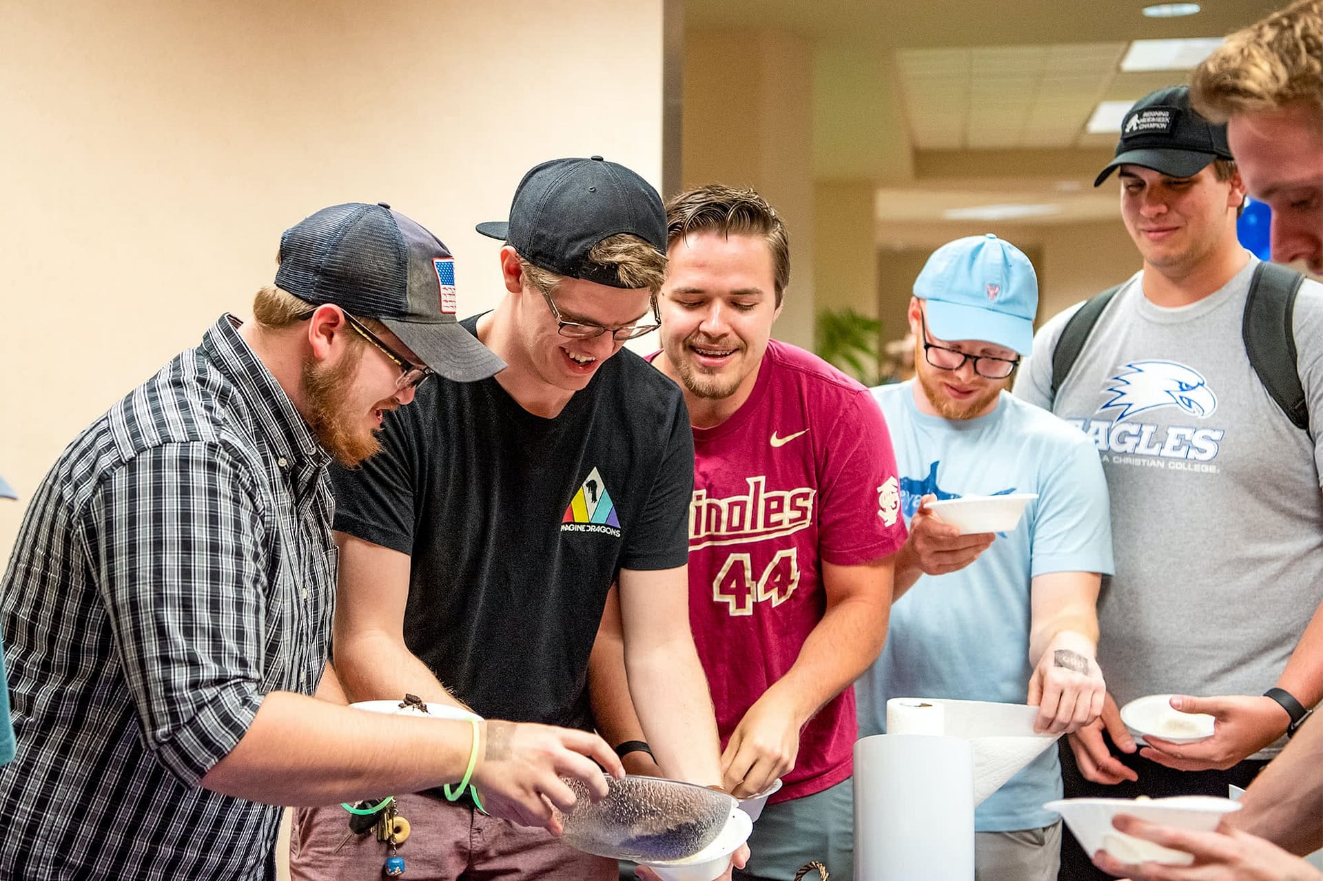 Male PCC students holding bowls.