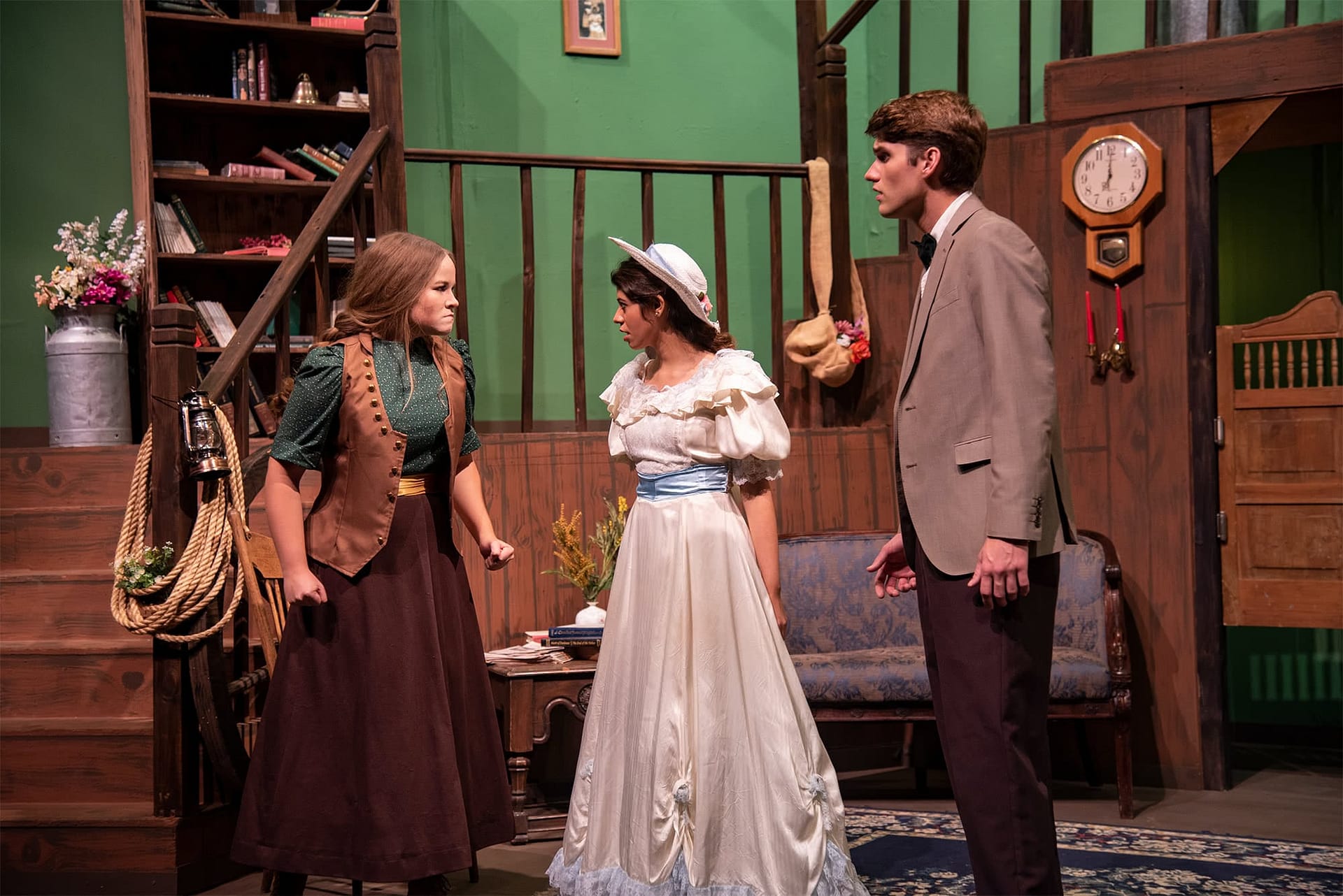 Two women argue while a man looks on