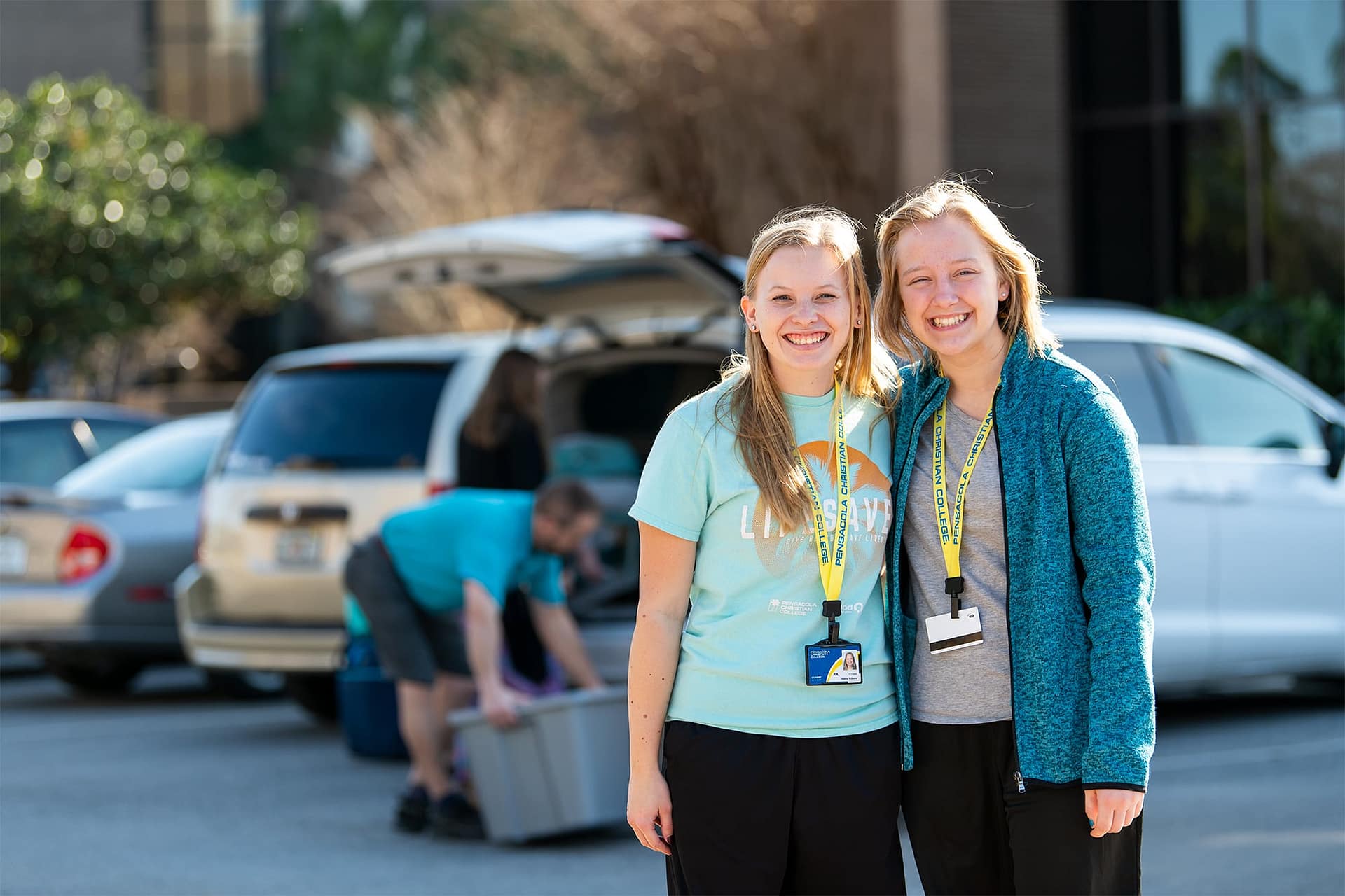 Two female students posing together for a photo in front of the Commons.