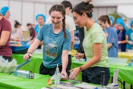 Students volunteering at the Meal Packing Party for One More Child.