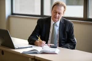 Nick Iwanowycz writing while sitting at a desk.