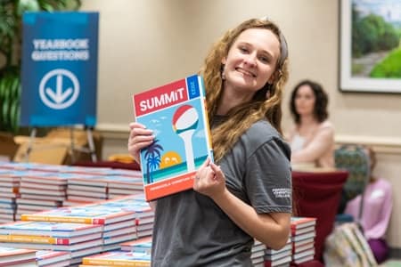 Student poses with the new Summit Yearbook.