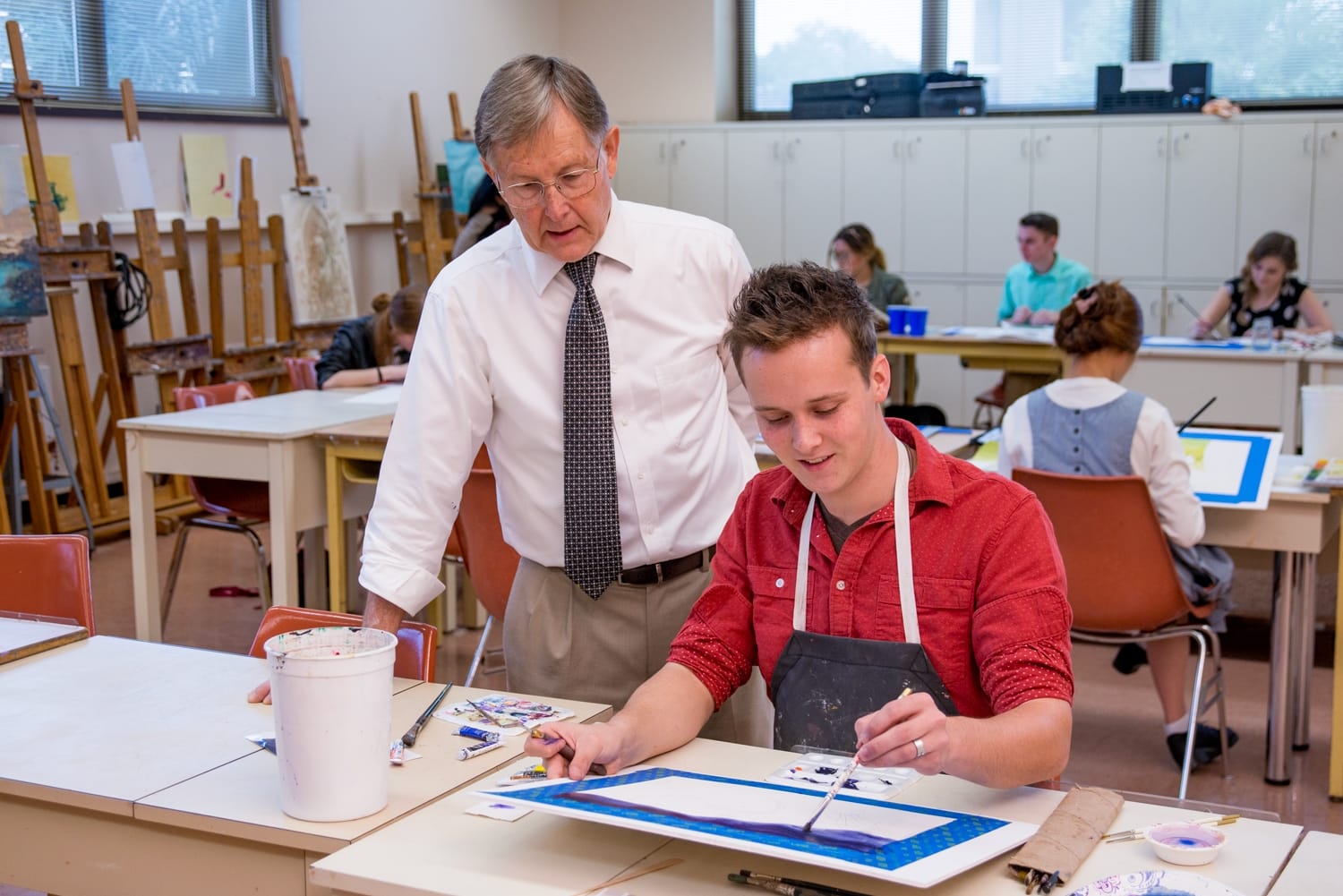 Stan Shimmin helping a student in an art class.