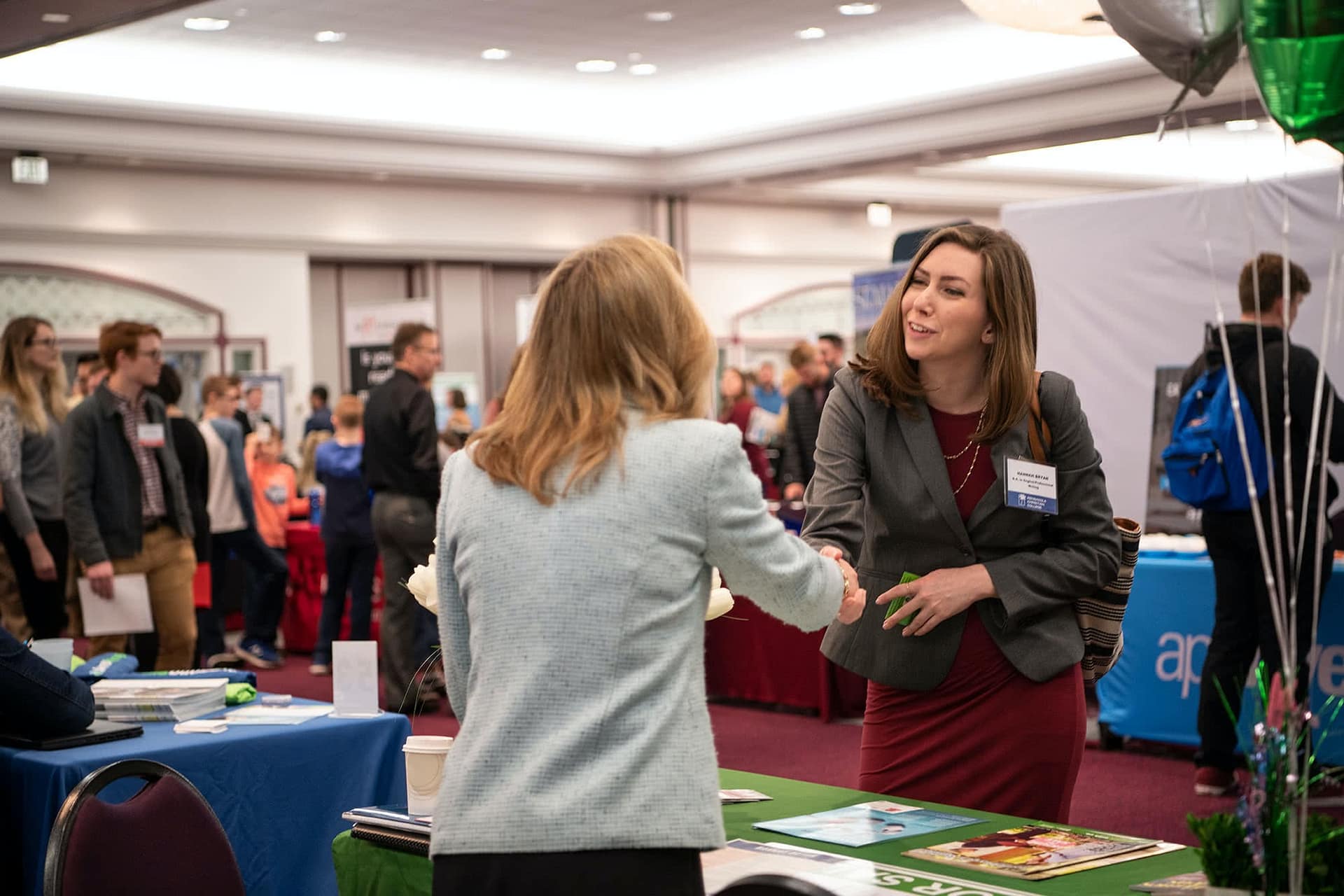 PCC senior speaking at a booth with a business representative at the 2020 Career Fair. 