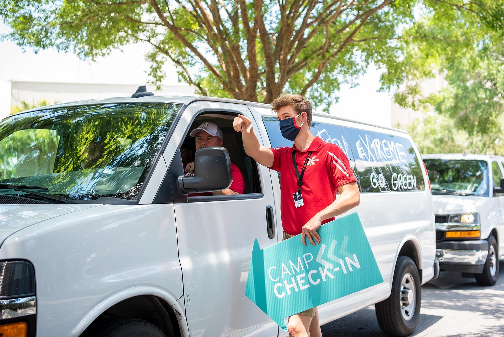 Teen Extreme camp counselor guiding visitors to check in location. 
