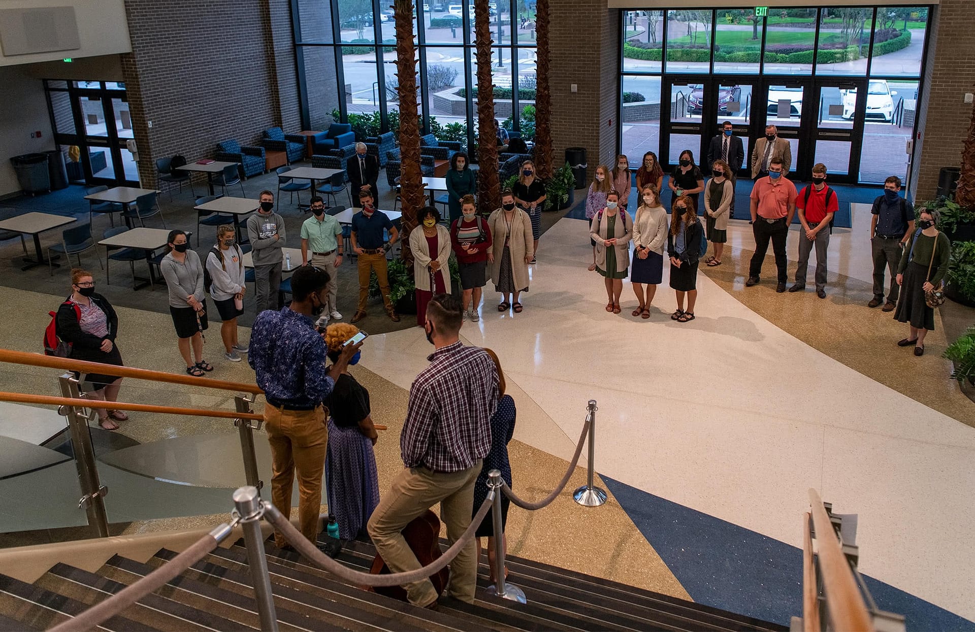 Student body members standing on PCC Commons steps and speaking to a crowd of students.