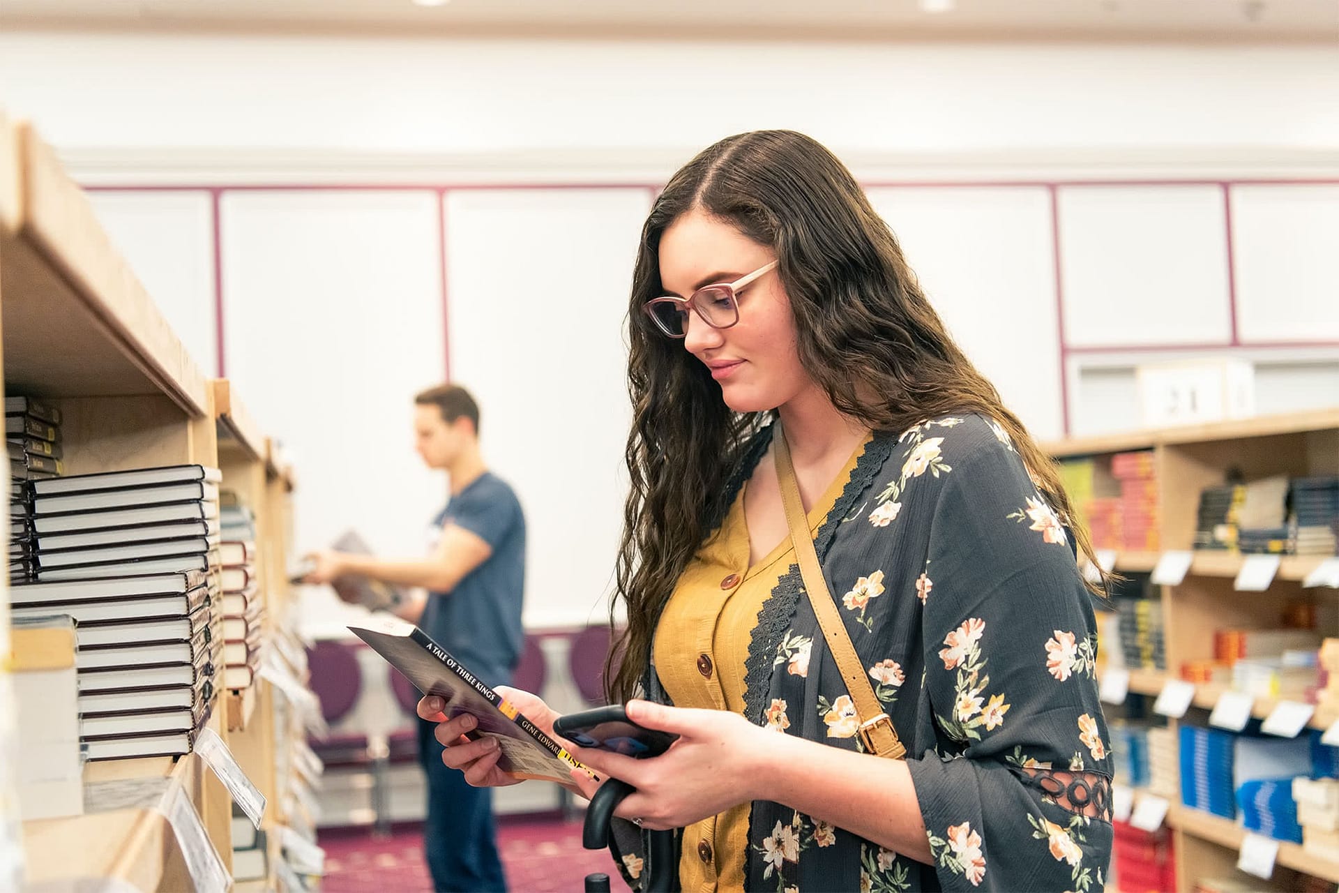 Female student looking at a book at the book sale.