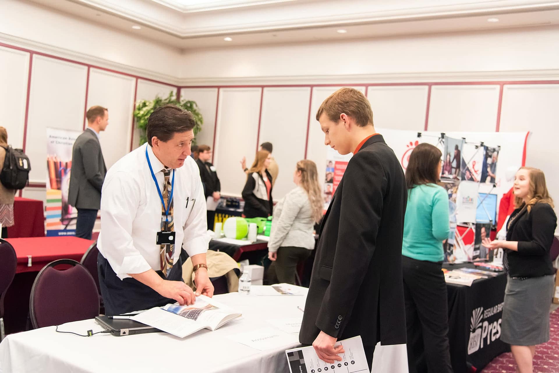PCC senior speaking at a booth with a business representative at the 2020 Career Fair. 