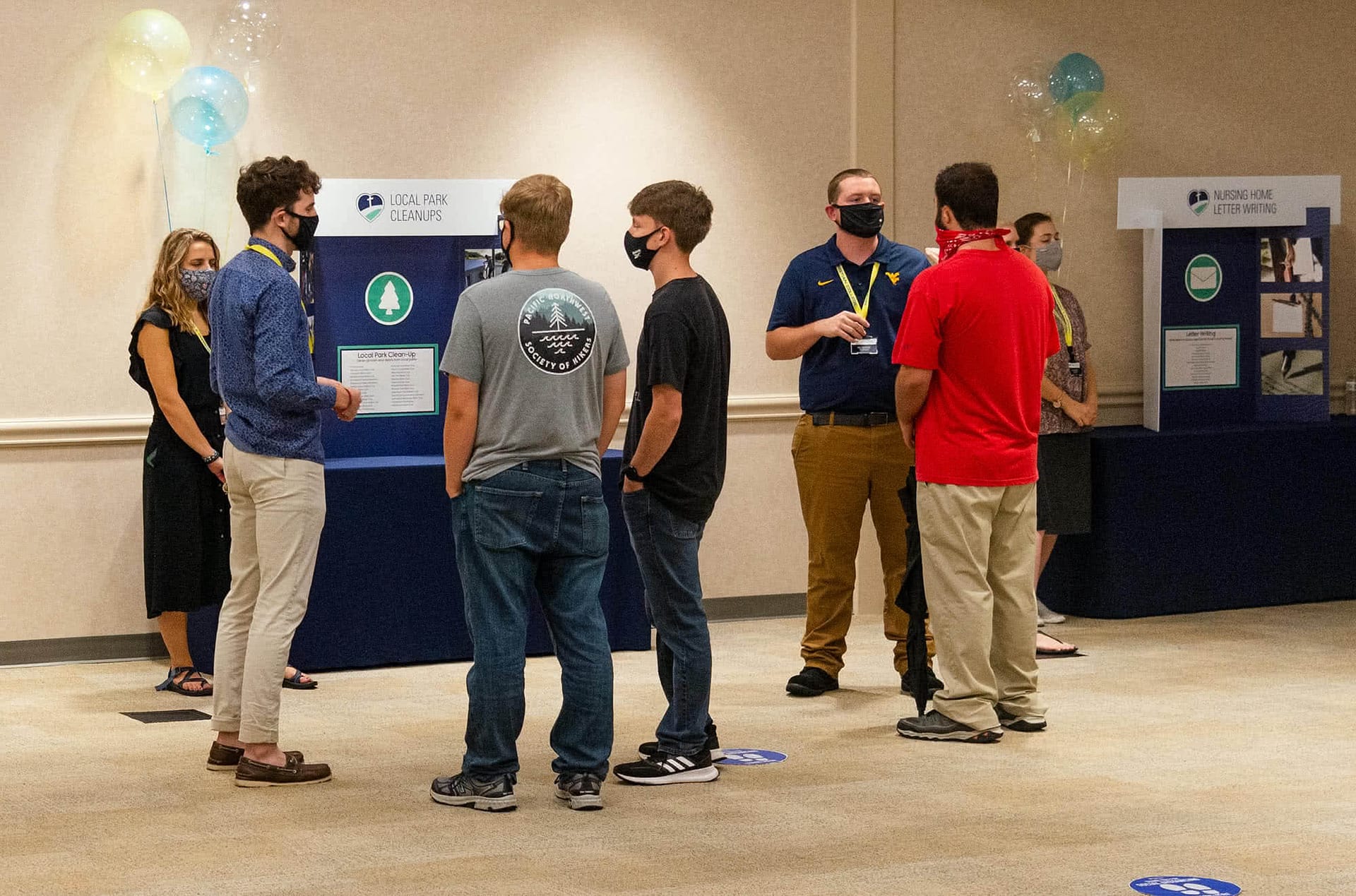 Students consider joining the "Local Park Cleanup" Christian service group at the Christian Service expo