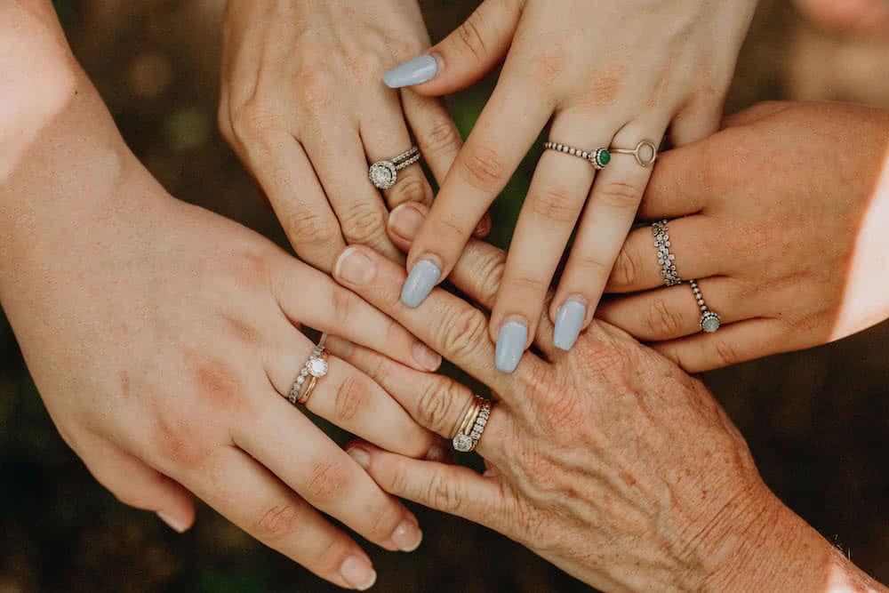Five hands with rings joined together.