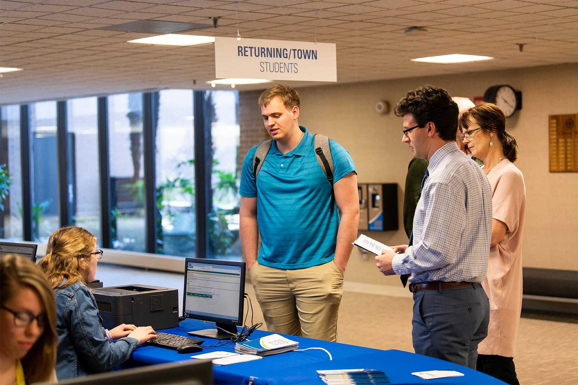 Male student checking in at academic center.