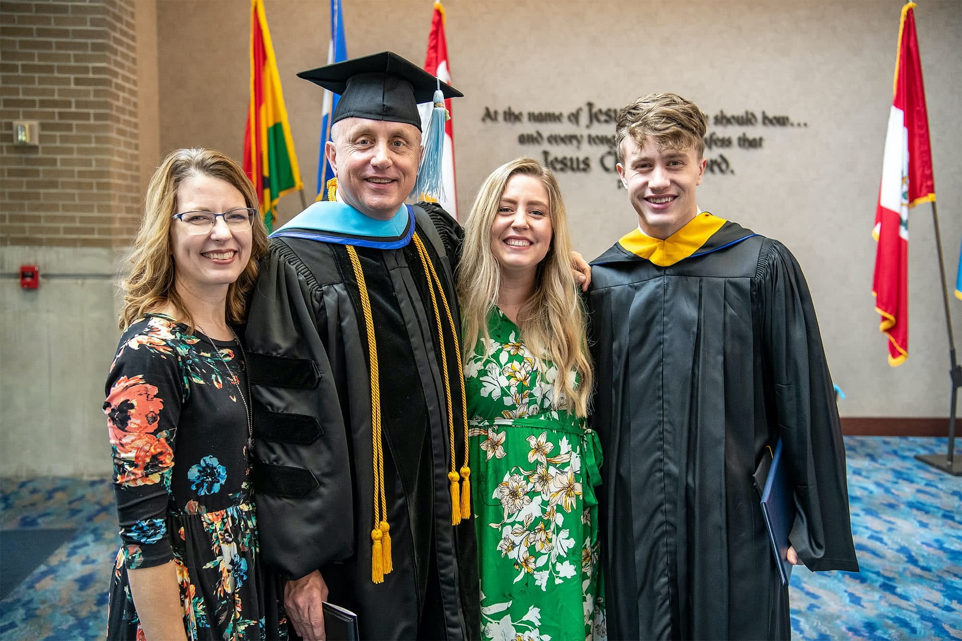 A graduate poses with his family