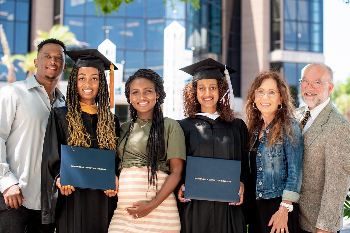 Arts and Sciences graduates pose with their family after Commencement.