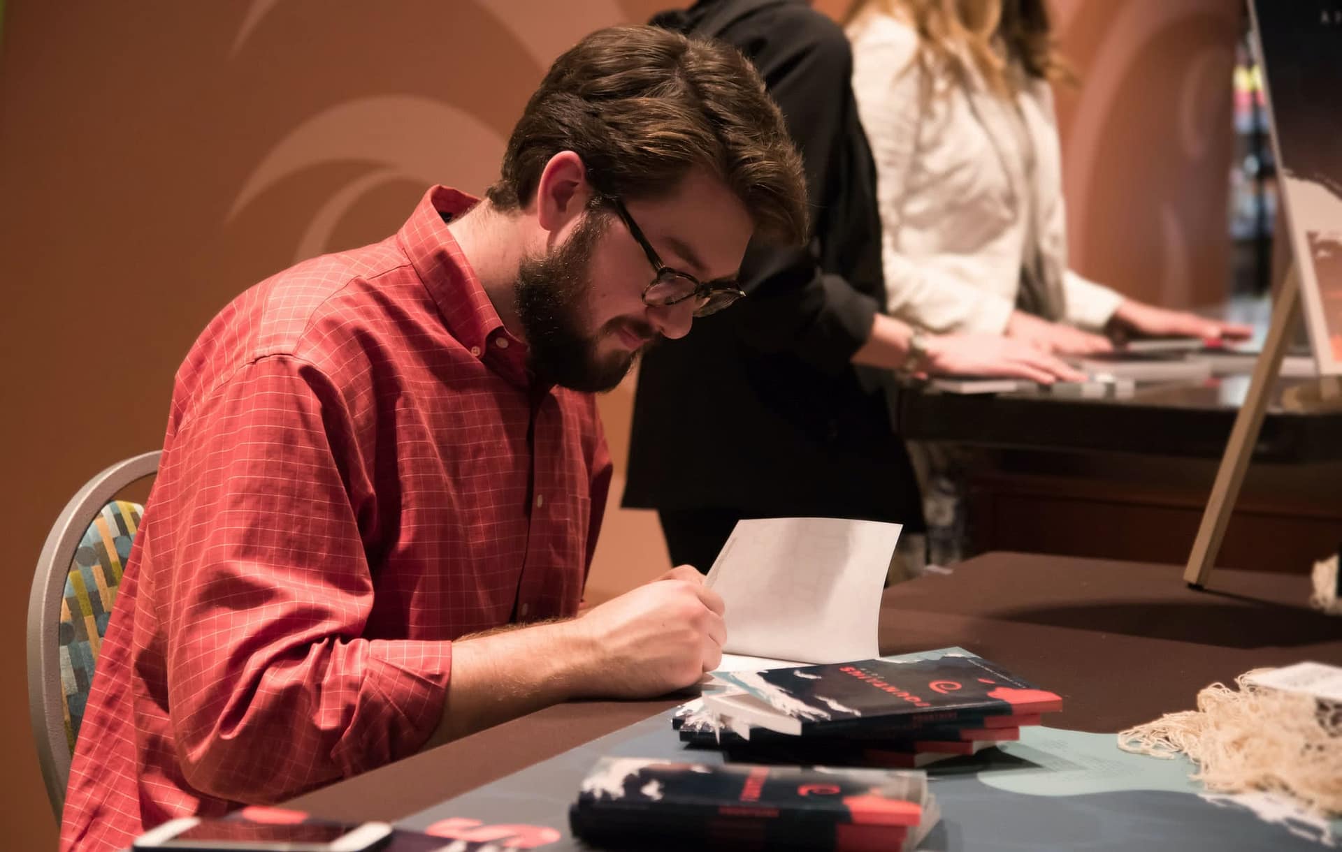 Man sitting and looking at a copy of 2019 Fountains.