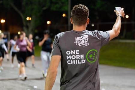 Runner wearing One More Child Mission Project T-shirt at the Missions Run 5K. 