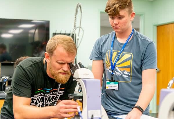 Dr. Sebastian Spencer looking into a microscope. 