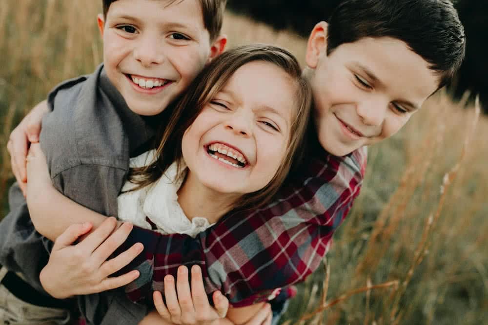 Children smiling and hugging.