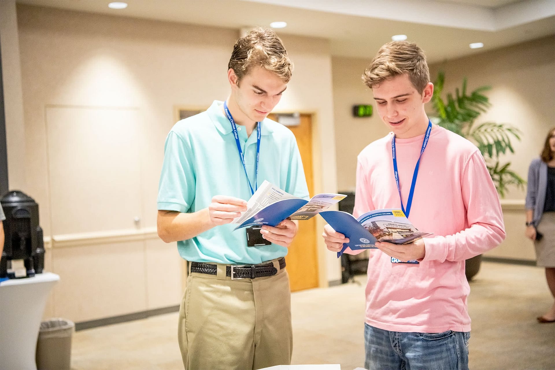 Two male students looking at College Getaway booklets.