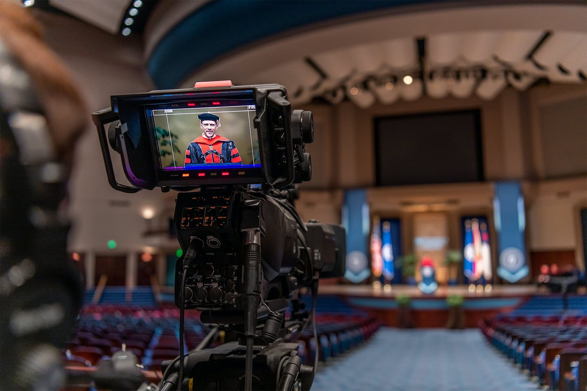 Camera view of Pastor Redlin speaking on Crowne Centre stage.