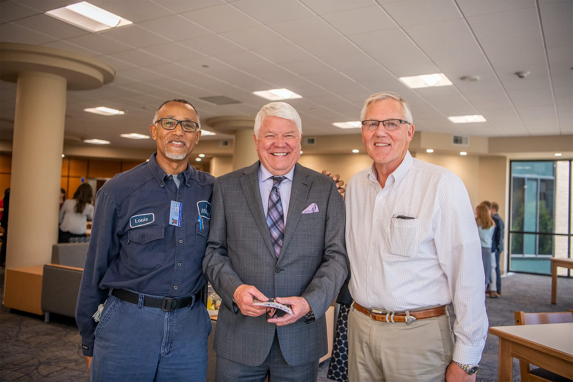 Two men posing for a photo with Dr. Bill Rice, III. 