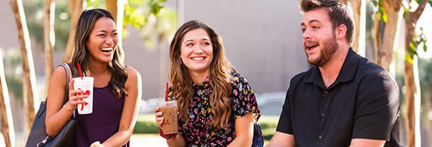 Three smiling students talking