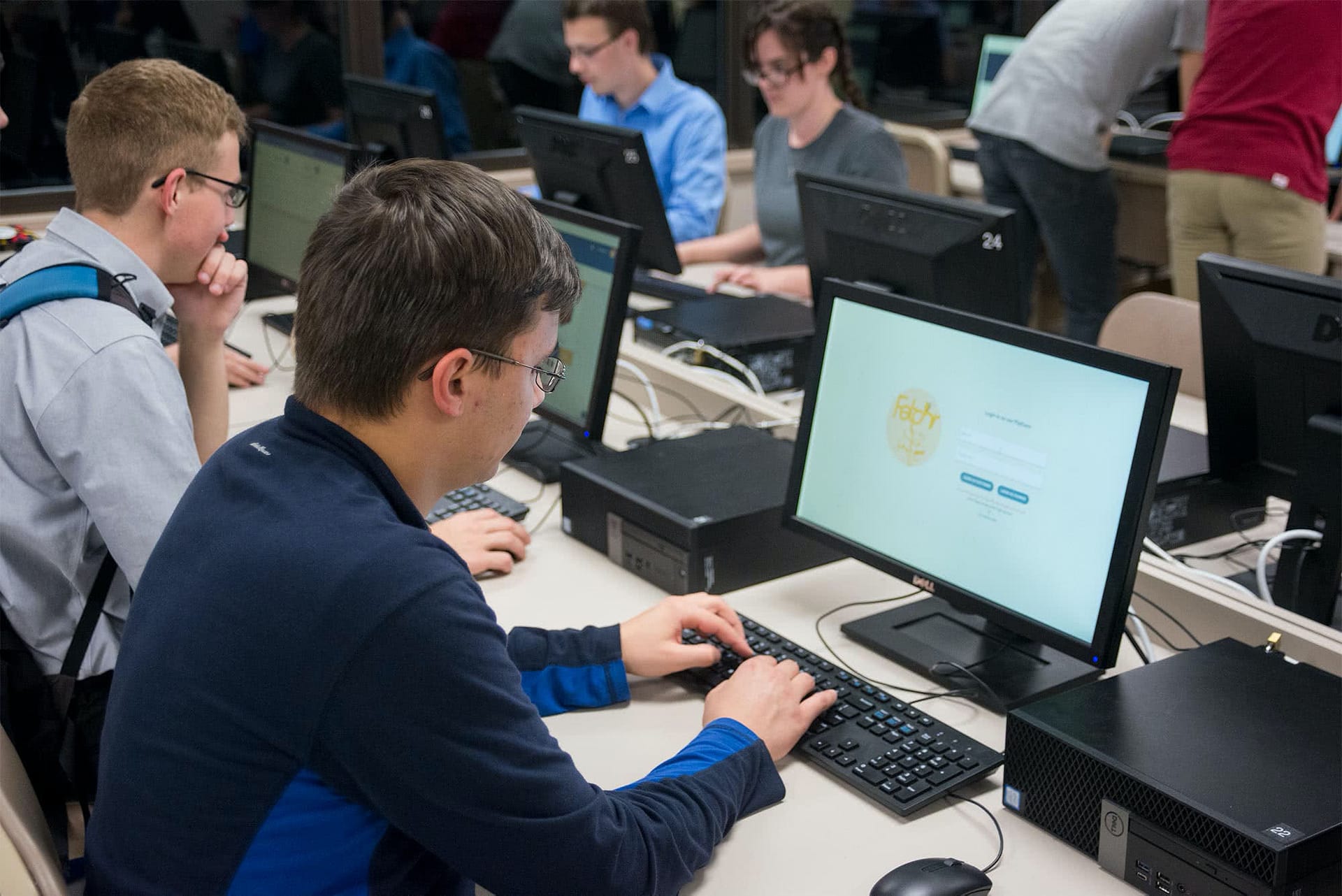 Male student typing on a computer. 