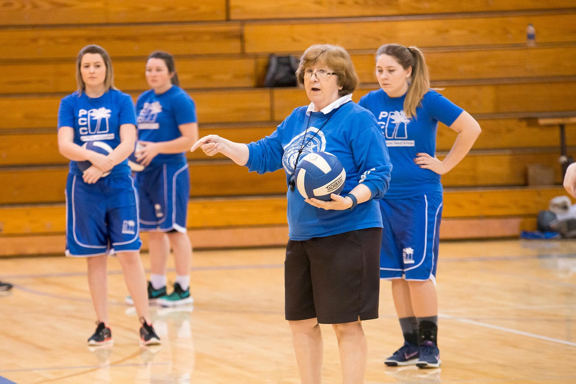 Female teacher leading a sports management volleyball class.