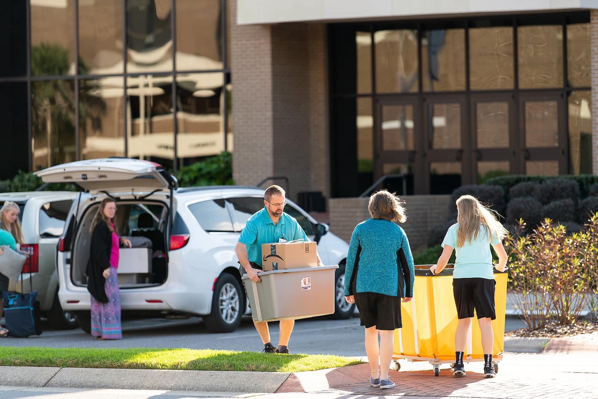 Students unloading their cars to move into the dorms in front of the Commons.