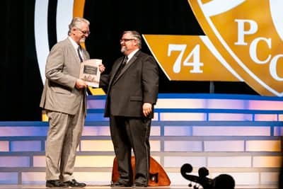 Dr. Shoemaker awards a commemorative plaque to Dr Matthew Beemer.