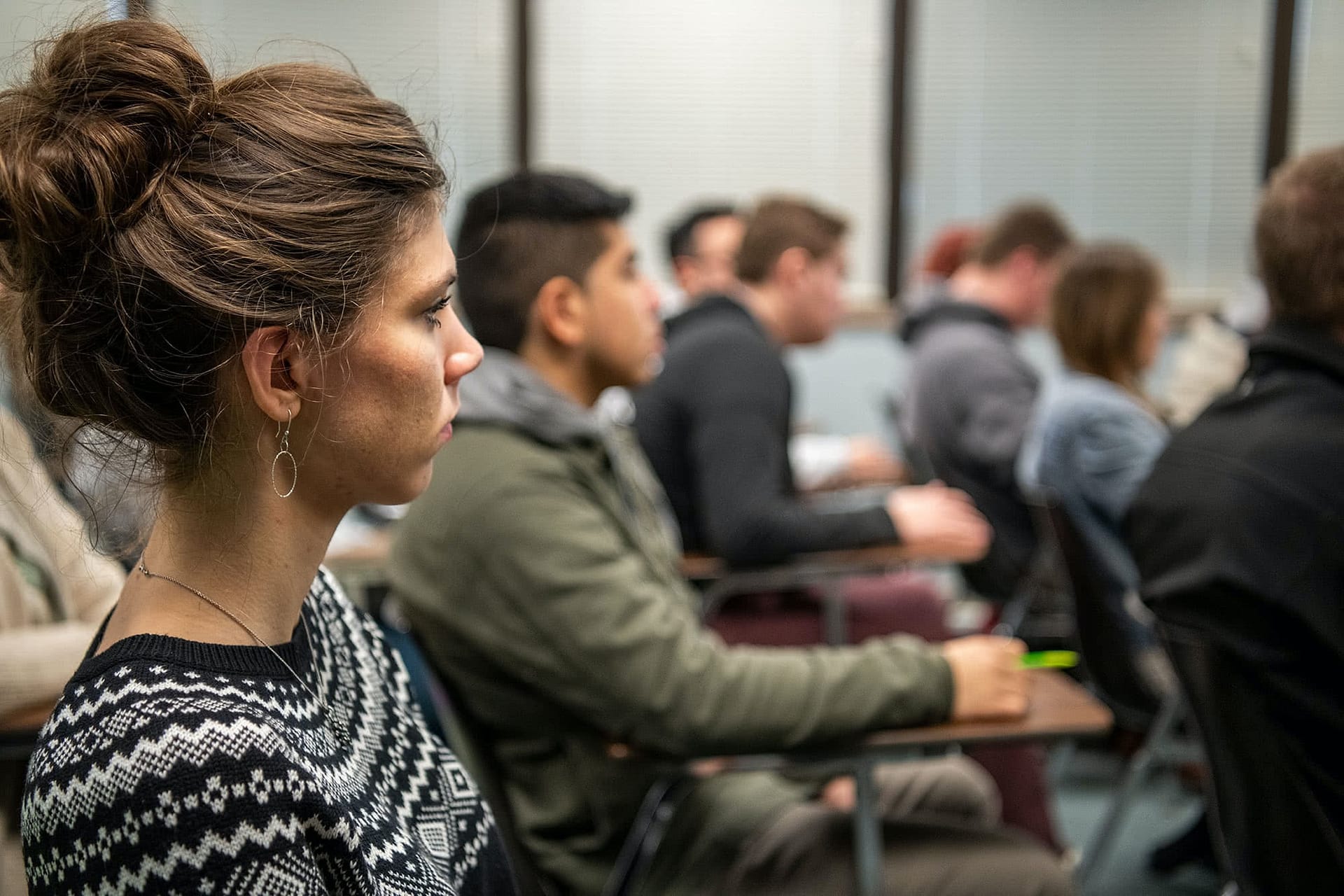 Side profile of a female student sitting in a classroom.