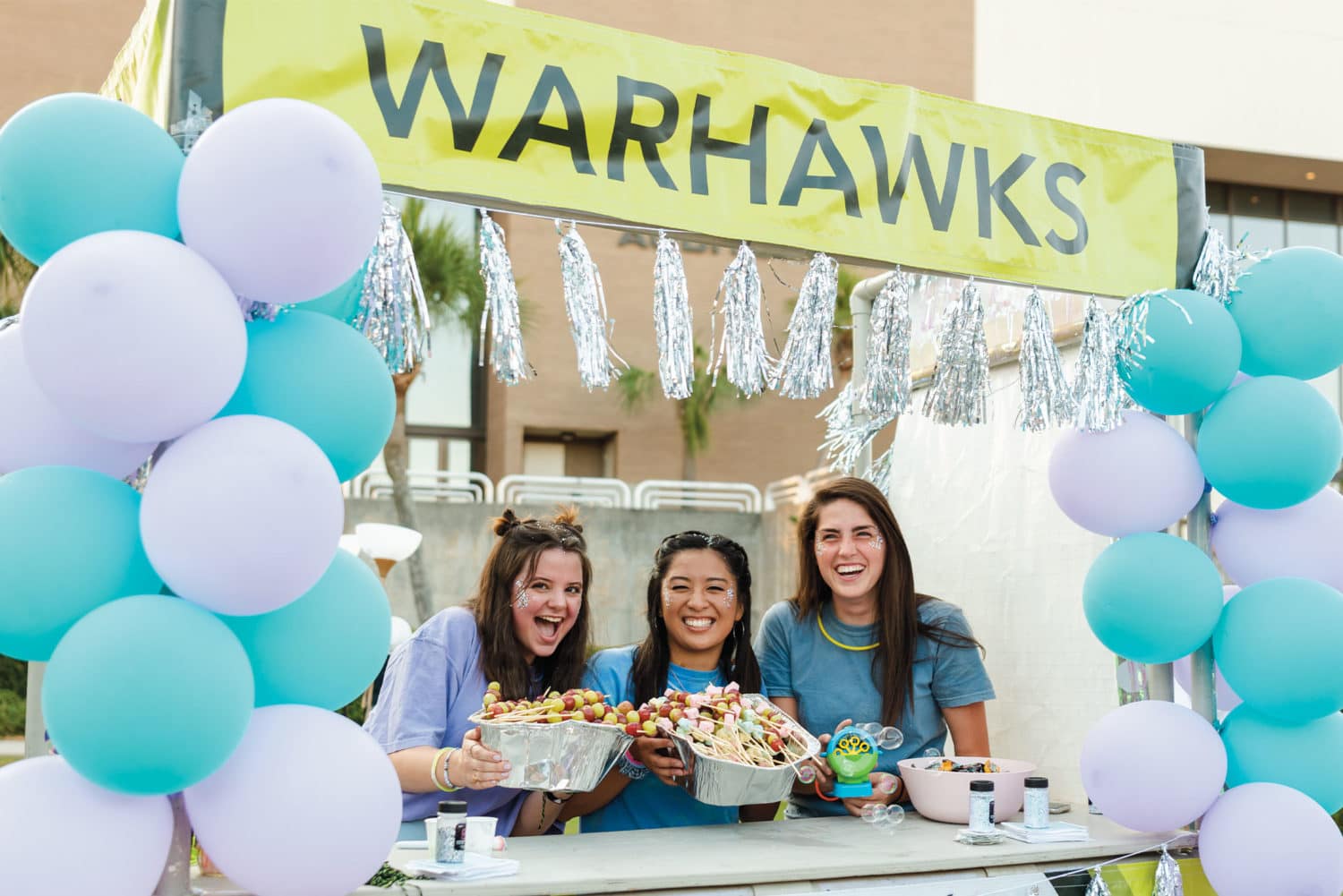 War Hawk girls at a booth during Greek Rush