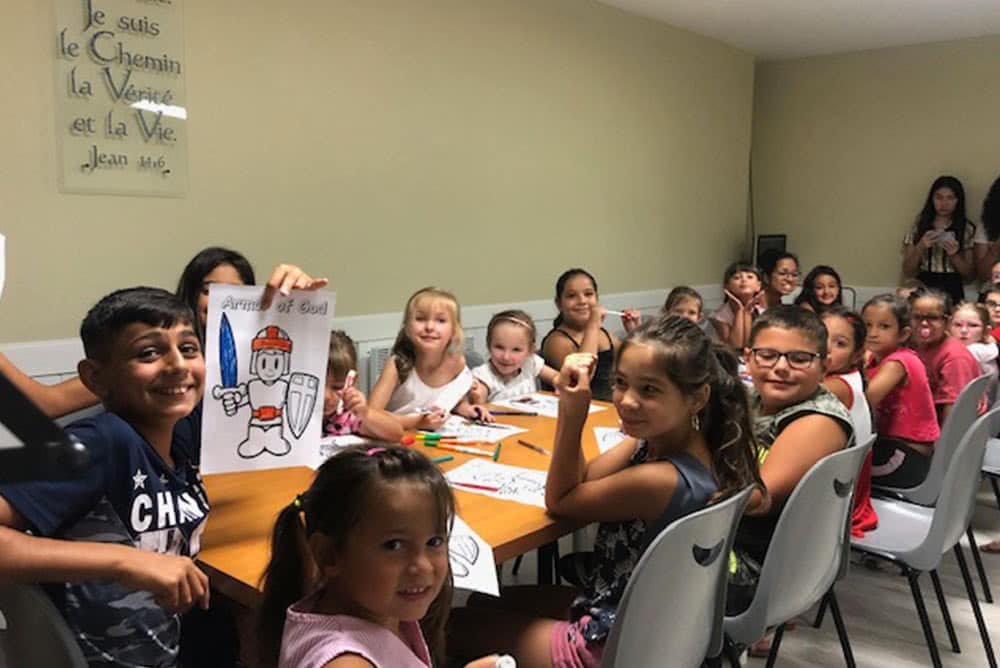 Children sitting at a table and coloring pictures. 