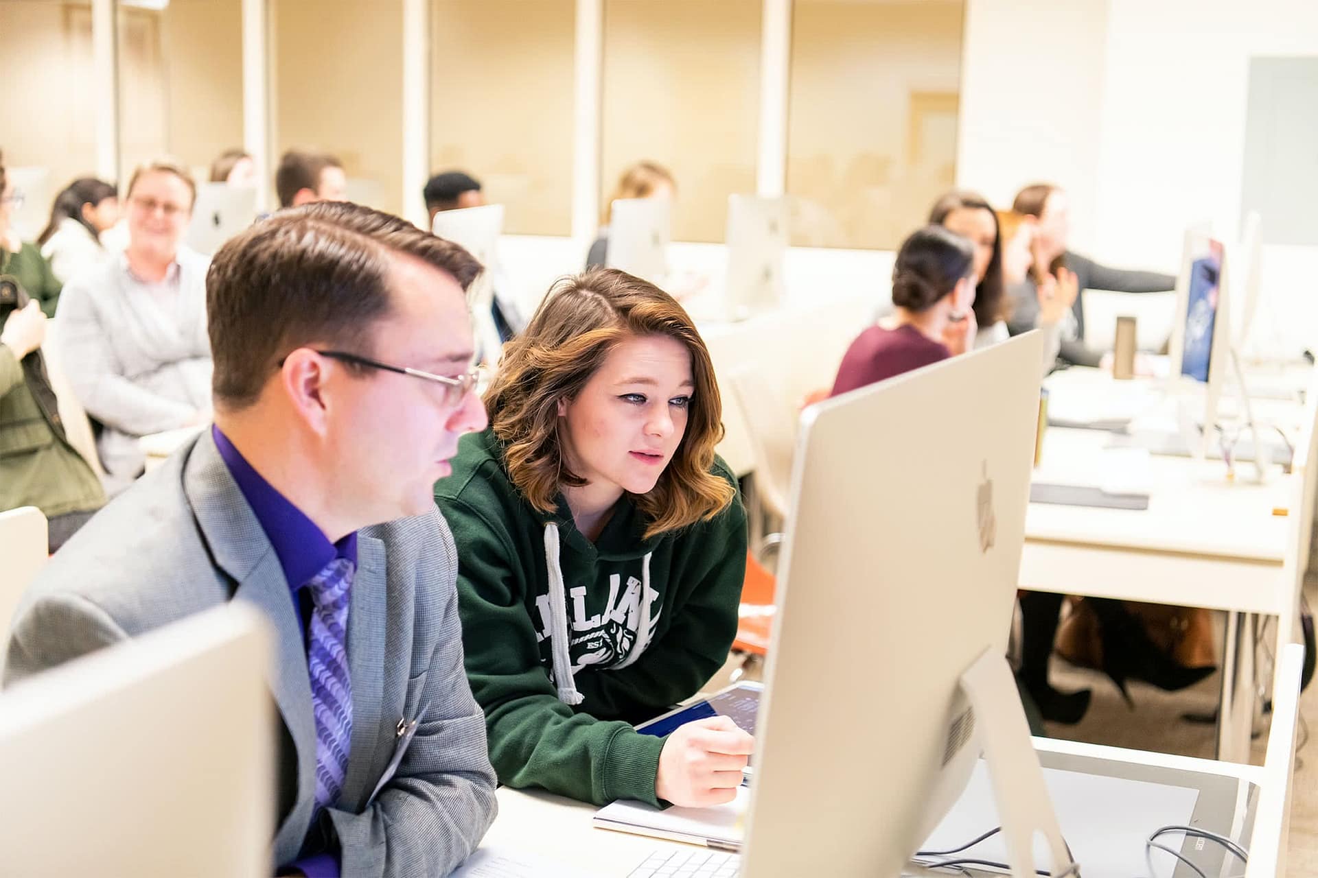 Female student with an enrollment advisor in the VPA computer lab.