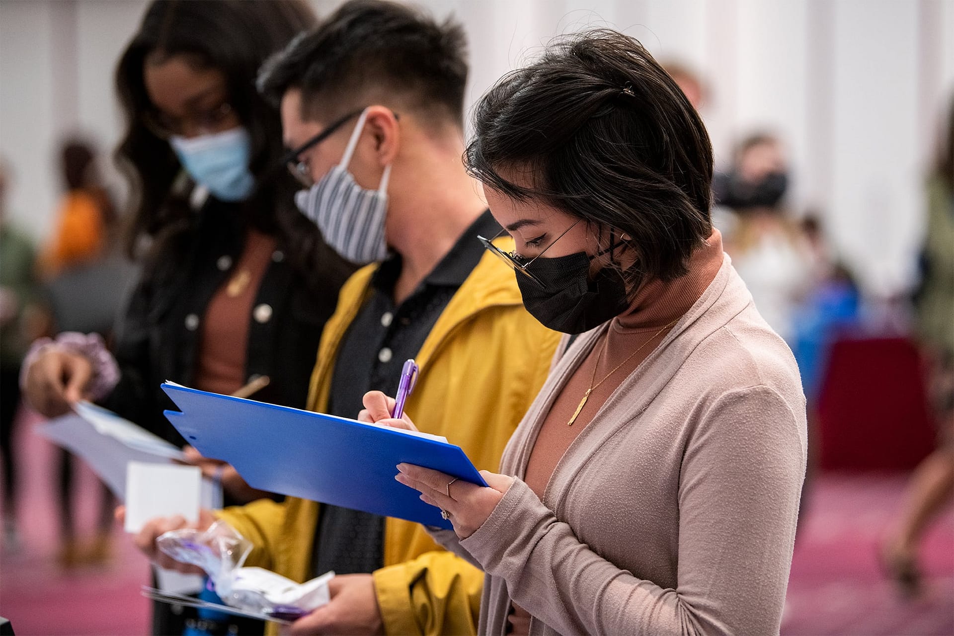 Female student filling out a form at a booth during the Health Professions Career Fair. 