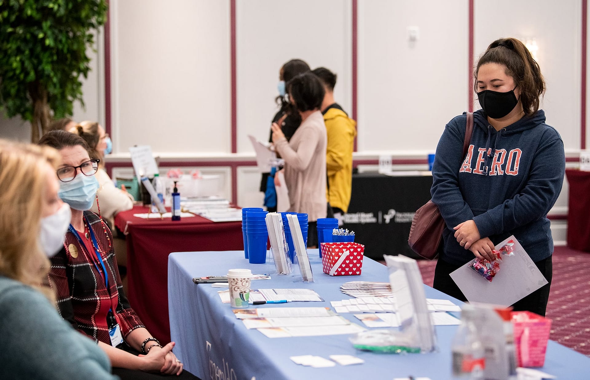 Female student standing at booth at the Health Professions Career Fair.