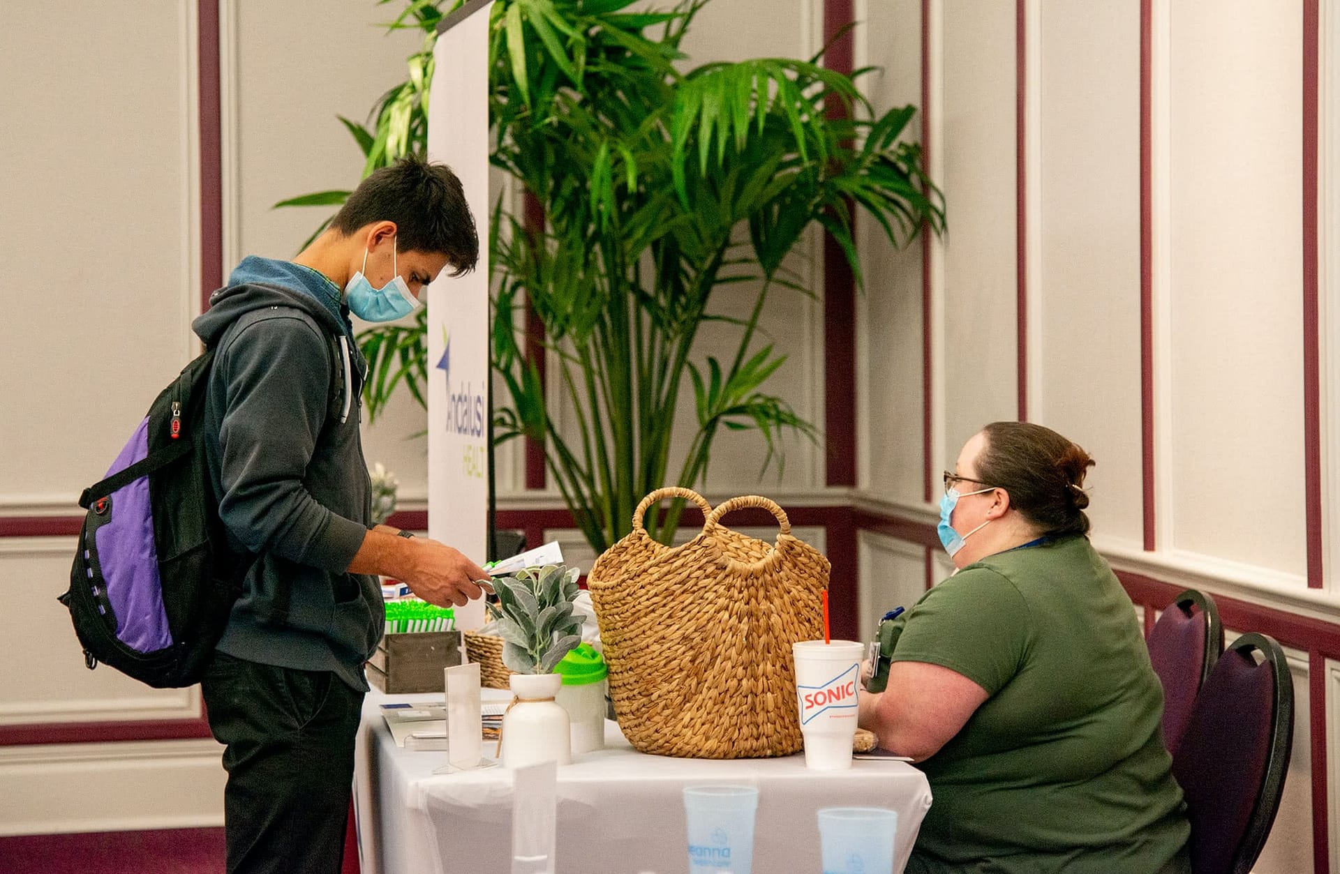 Male student looking at information at a booth at the Health Professions Career Fair.