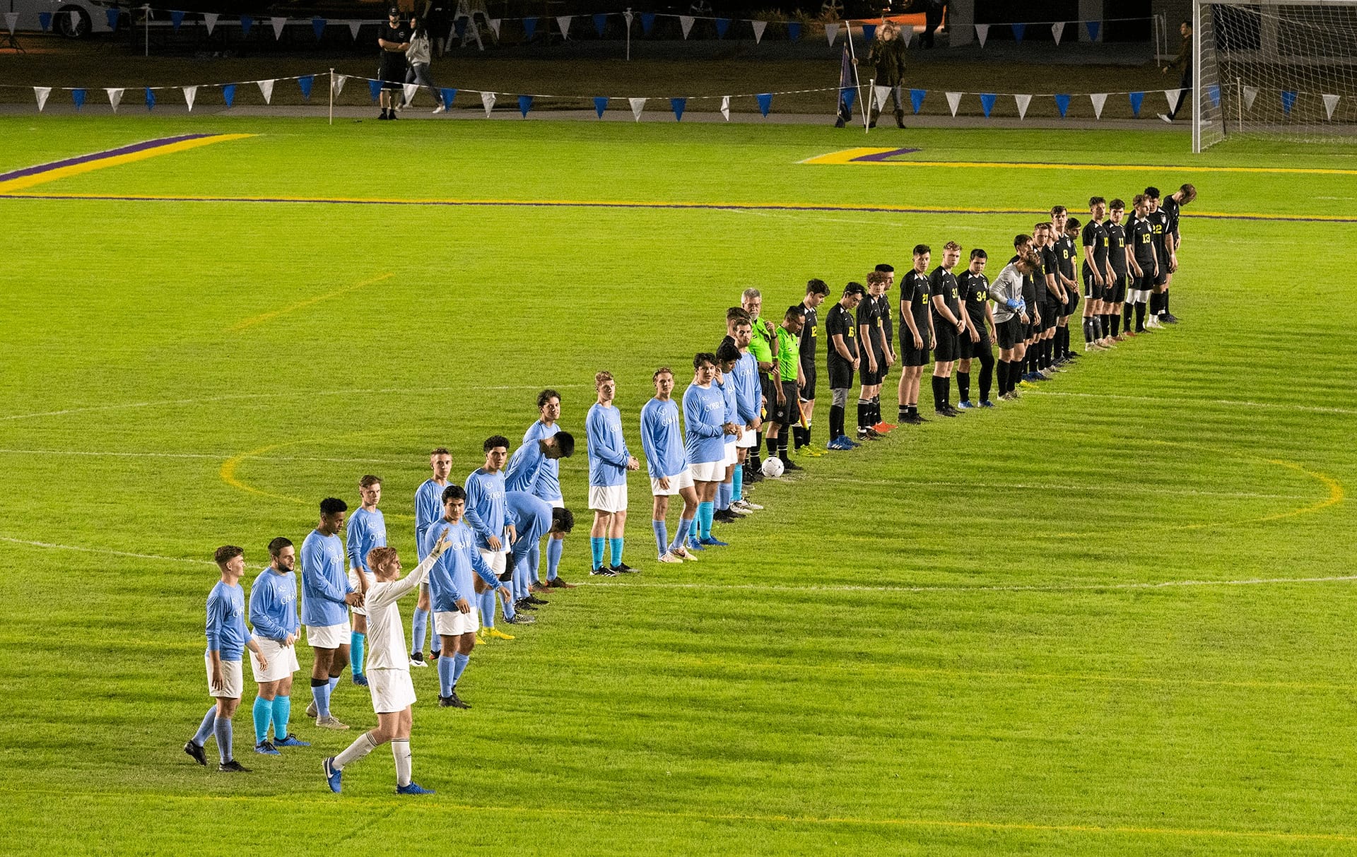 Male students standing in a line on Eagle's Field.