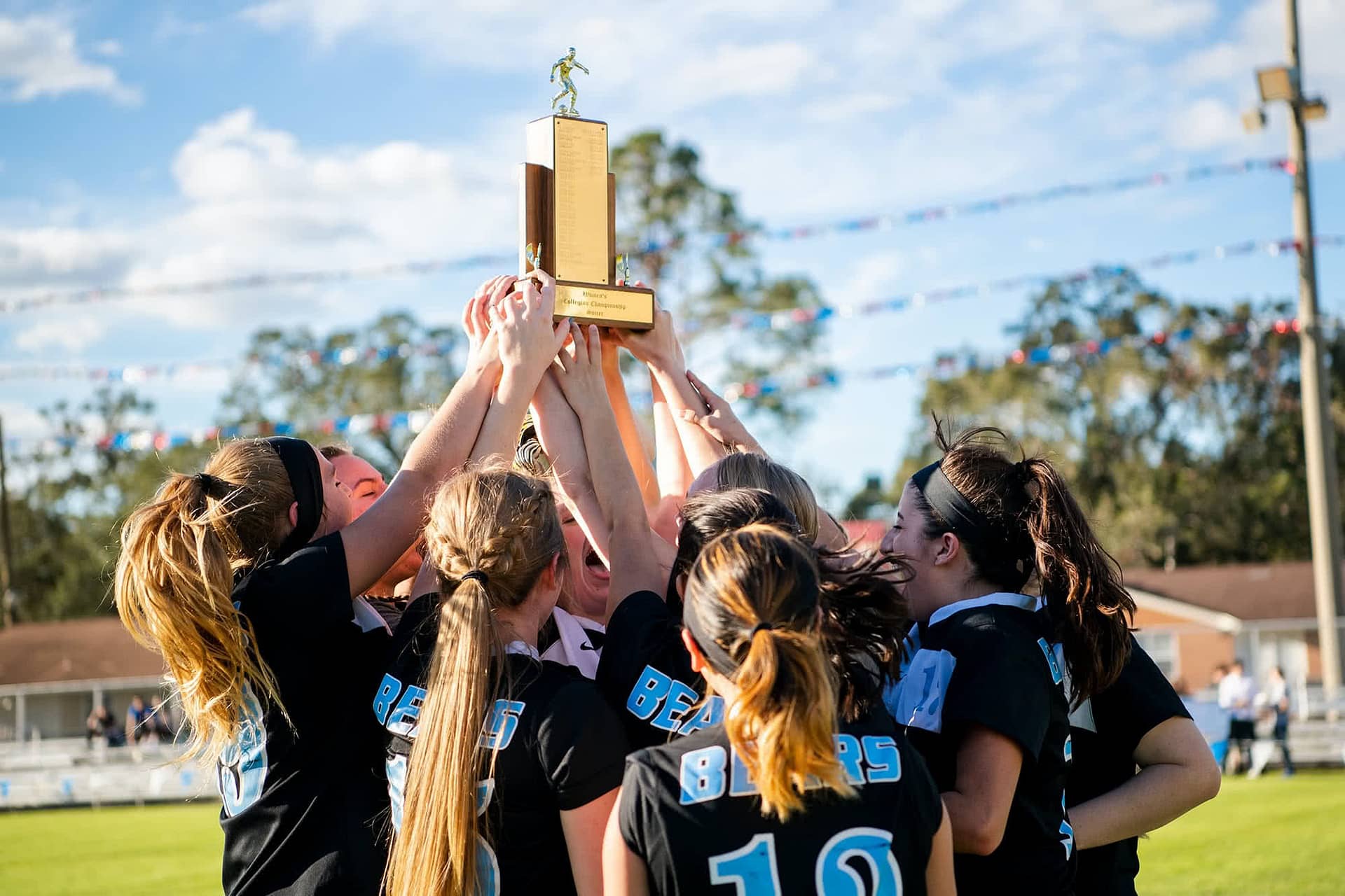 Women's Turkey Bowl 2020 winners holding trophy up in the air.