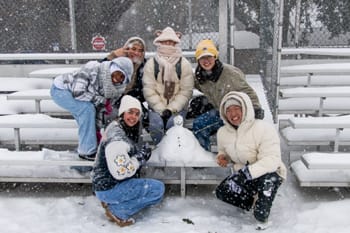 PCC Students pose with their snowman on the Eagle Field bleachers.