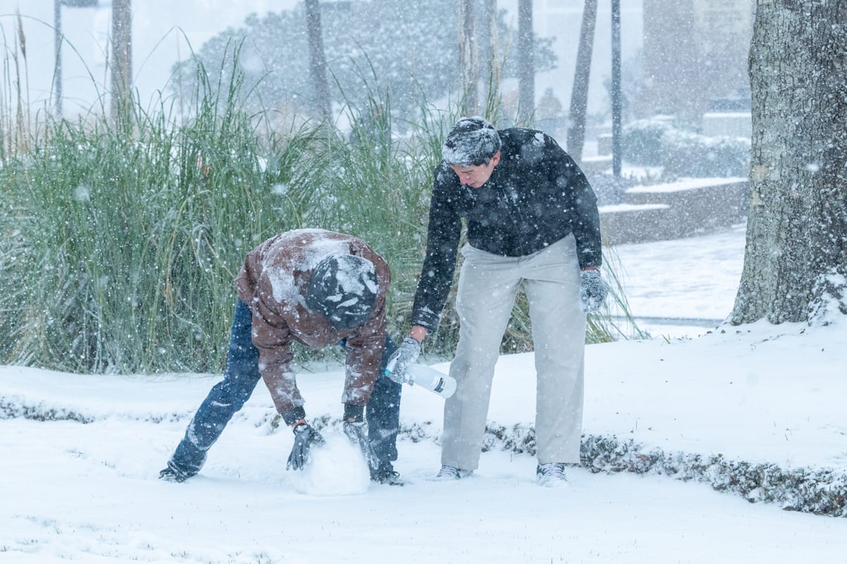 PCC guys try to build a snowman in the powdery snow.