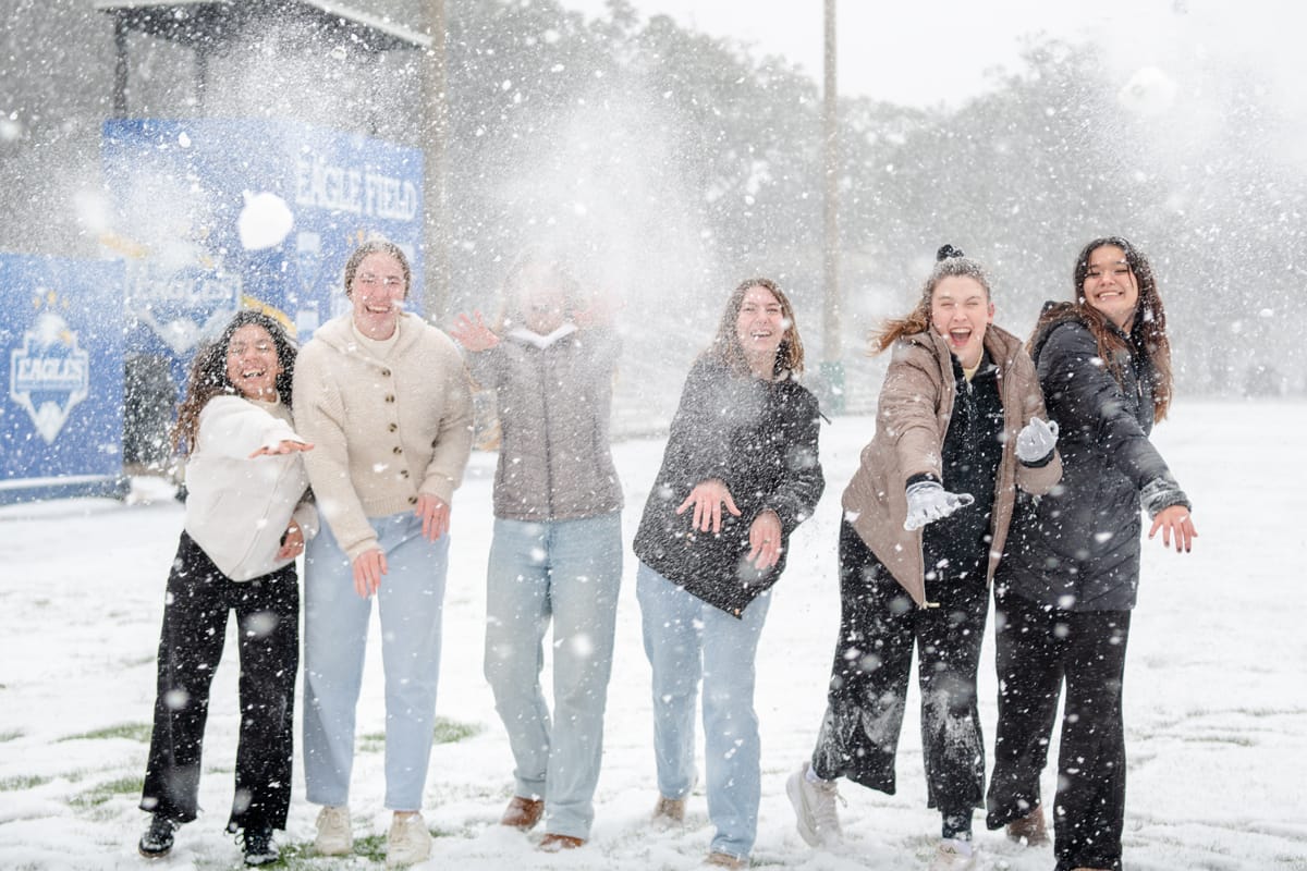 PCC girls throw snow and snowballs at the camera.