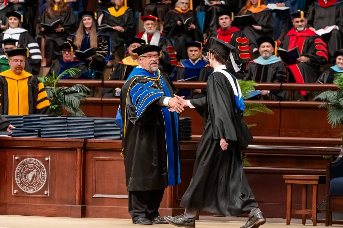 Graduate walks across the stage at the Arts and Science PCC Commencement 2025
