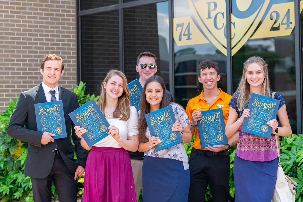 PCC Student group shows off the beautiful blue and gold covers of their new 2024 Summit Yearbooks
