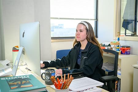 Graduate assistant editor works on the Summit yearbook