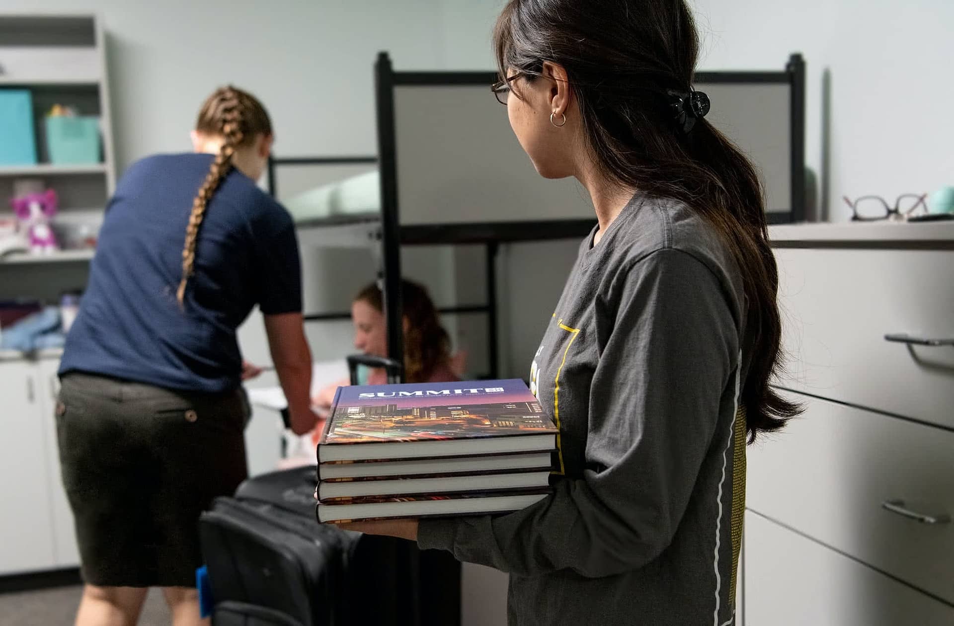 Female PCC students distributing Summit Yearbooks.