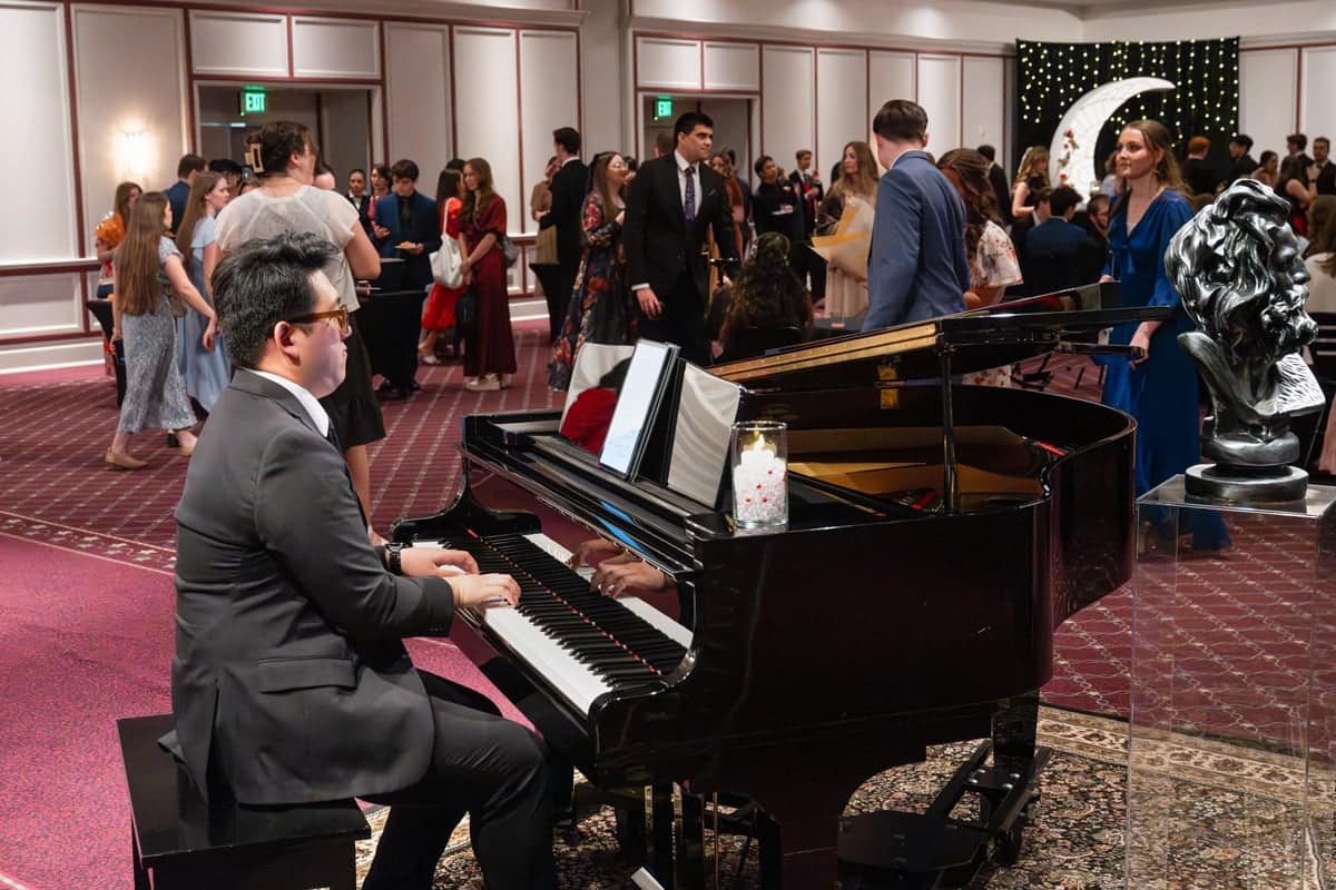 Pianist plays the piano while the students mingle at the PCC Red Carpet Event.
