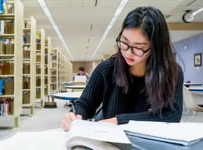A female student studies in the library