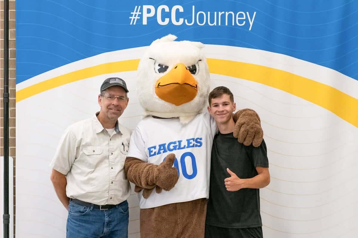 PCC student poses with Eagor during Welcome Weekend