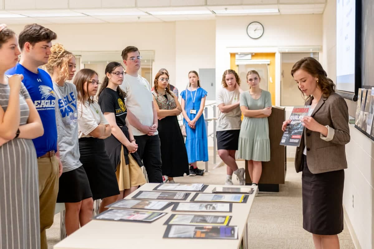 PCC graphic design teacher reviews a student magazine project in a design critique