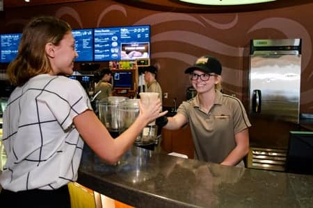 PCC student worker serving a coffee at Common Grounds